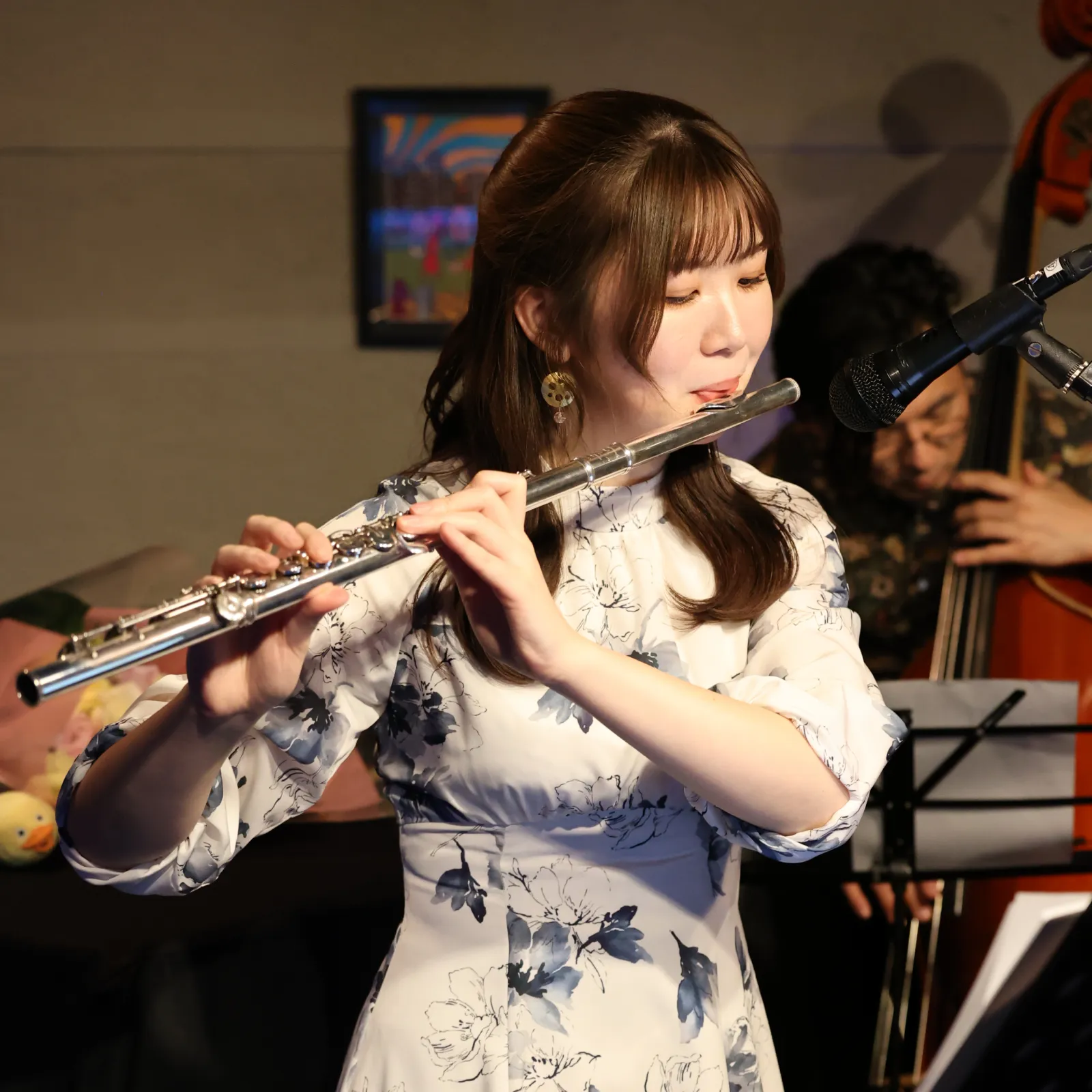 スポットライトが当たったシックなステージでフルートを演奏する永田梨紗の写真